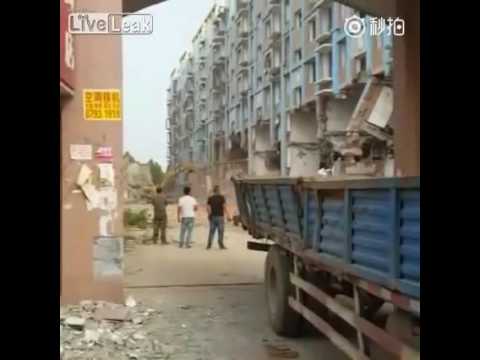 بالفيديو لحظة انهيار بناية ضخمة فوق حفار