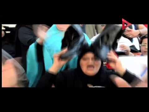 سيدة تضع حذاء الجيش فوق رأسها أمام دار القضاء